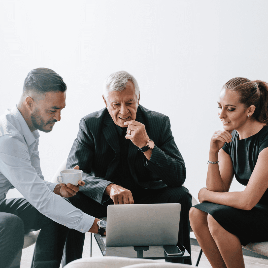 Group of three business professionals working together on new business plan.